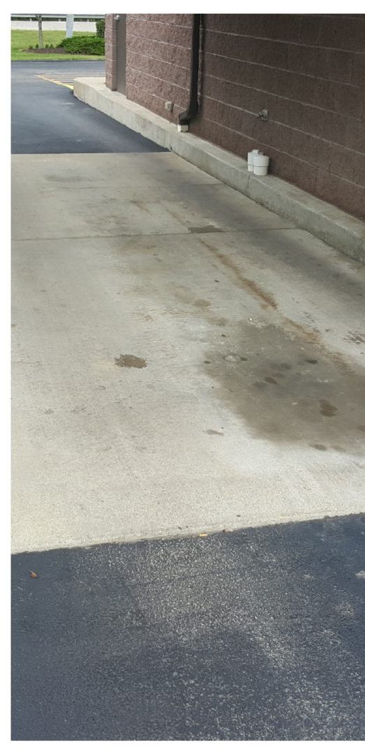 Bank drive-through lane before cleaning, stained with grease and traffic film