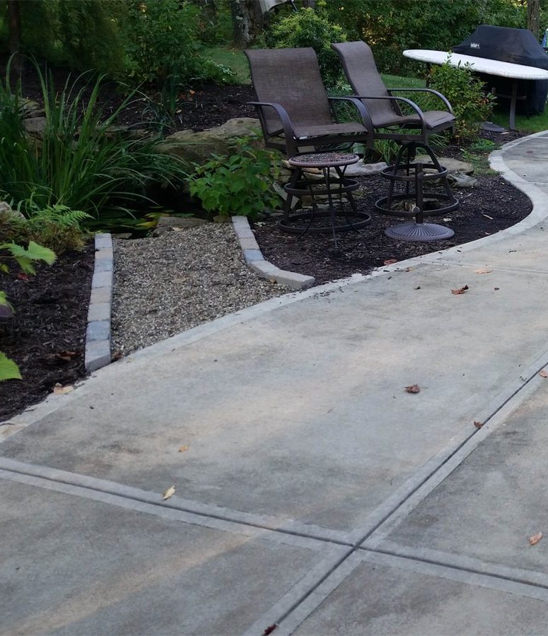 Concrete patio and walkway before cleaning, darkened with dirt