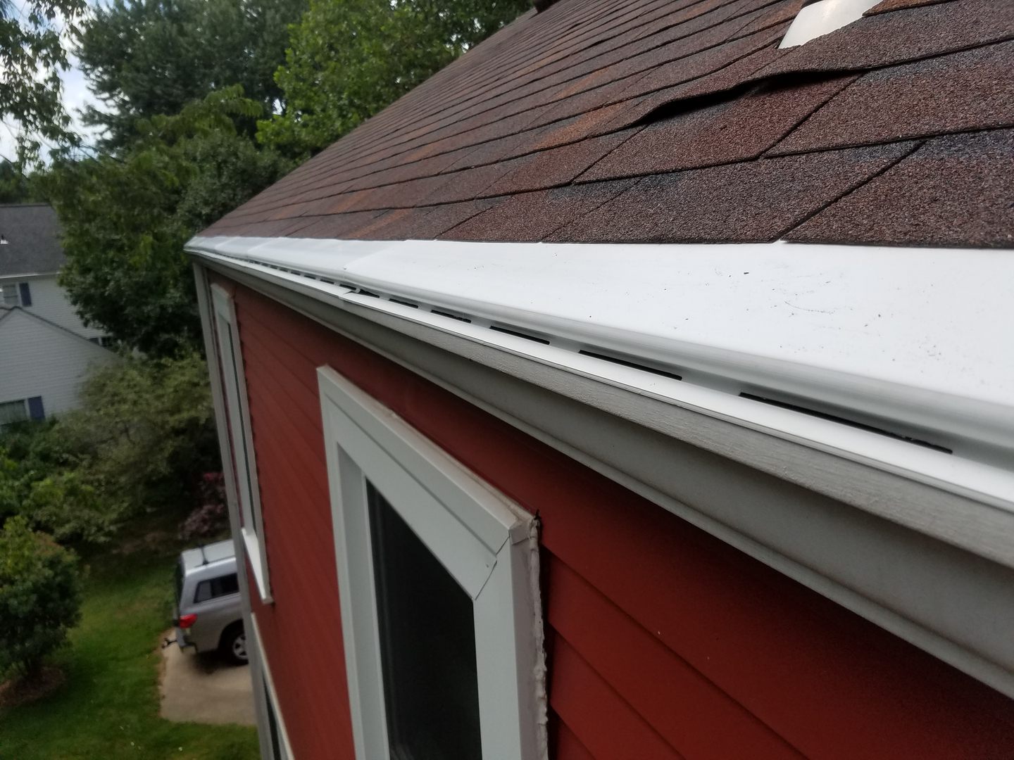 Newly installed gutter guard along a residential roofline